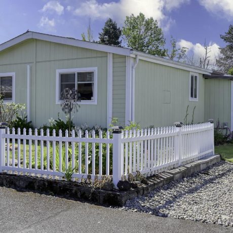 home exterior with plants and white fence